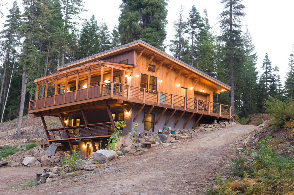 This is an example of a small rustic house exterior in Seattle with three floors, wood cladding and a lean-to roof.