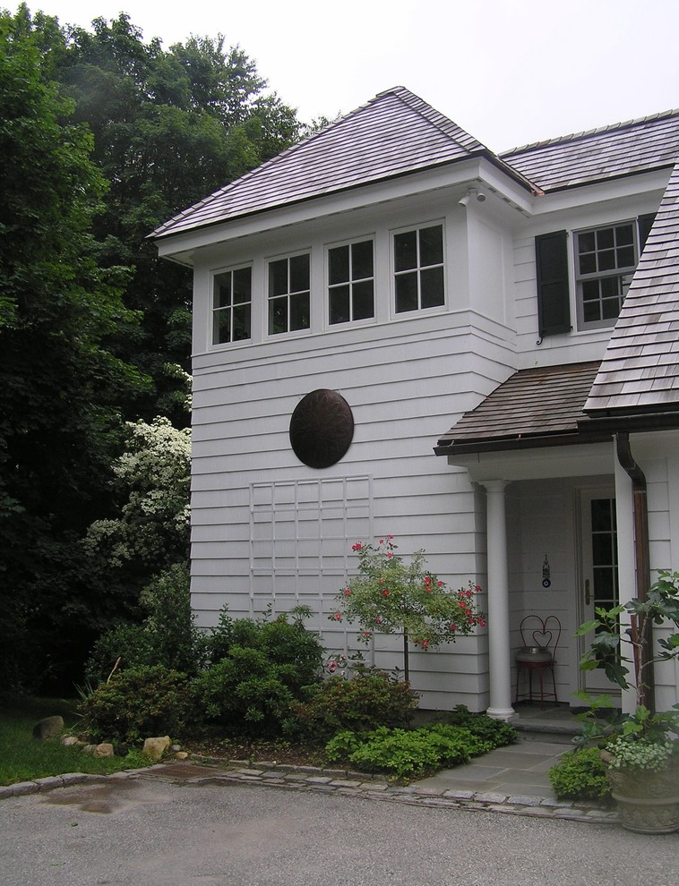 Пример оригинального дизайна: маленький, двухэтажный, деревянный, белый дом в классическом стиле с двускатной крышей для на участке и в саду