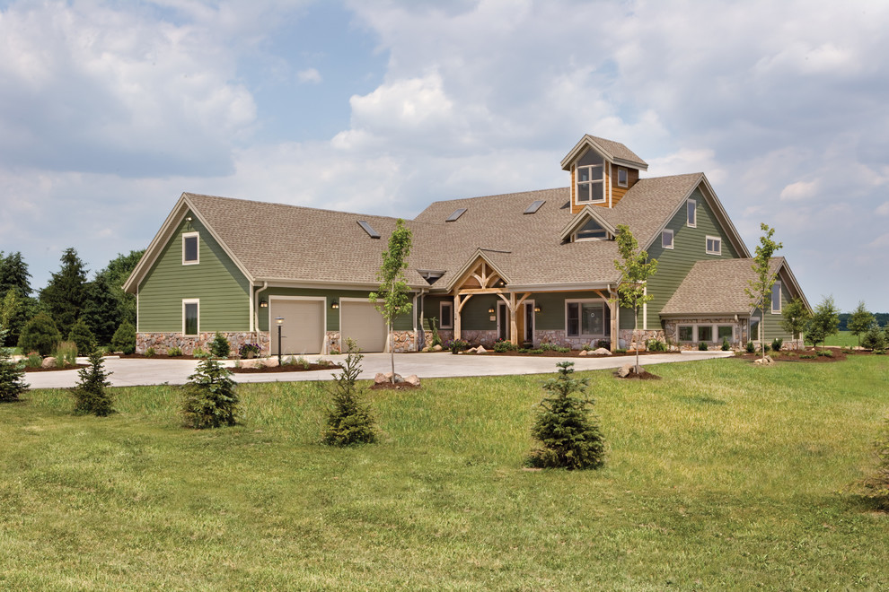 Cette image montre une façade de maison verte rustique à deux étages et plus avec un toit à deux pans et un revêtement mixte.