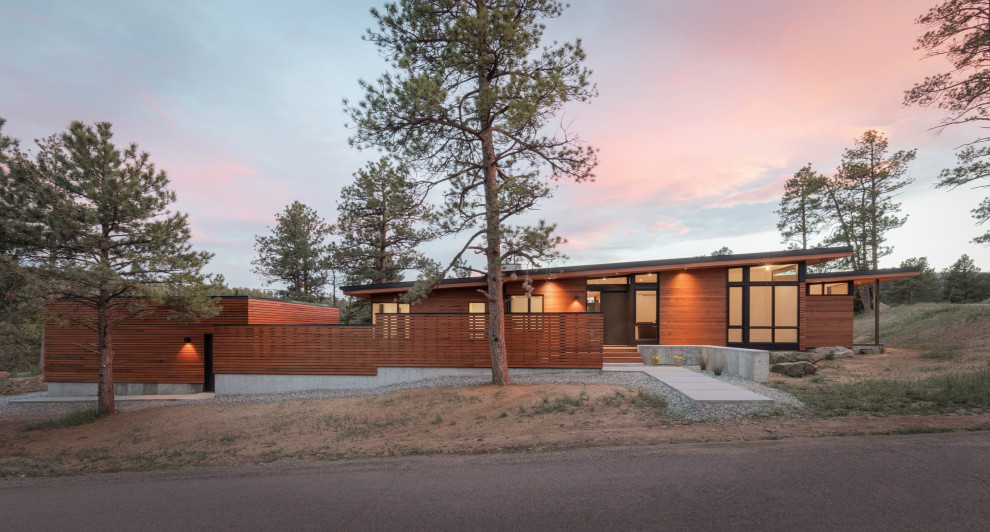 Inspiration for a 1950s one-story wood house exterior remodel in Denver with a shed roof