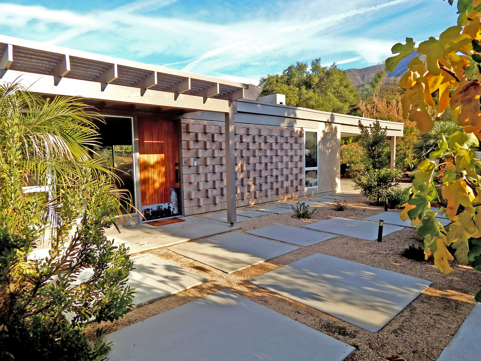 Medium sized and brown midcentury bungalow house exterior in Los Angeles with mixed cladding.