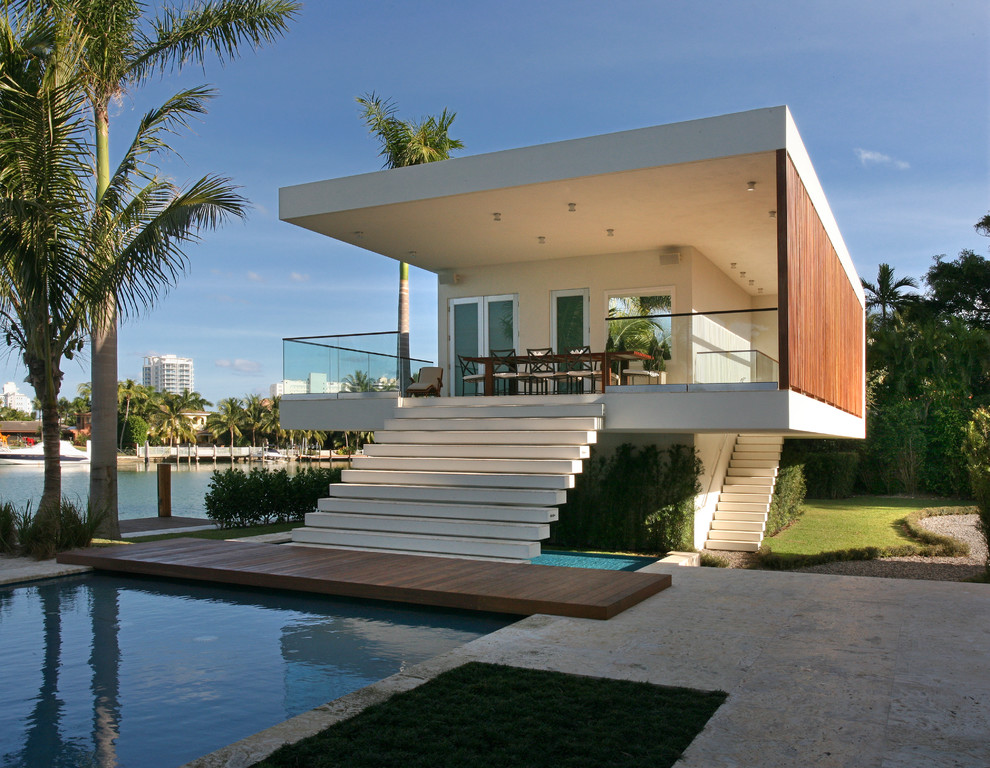 Example of a large minimalist white one-story flat roof design in Miami