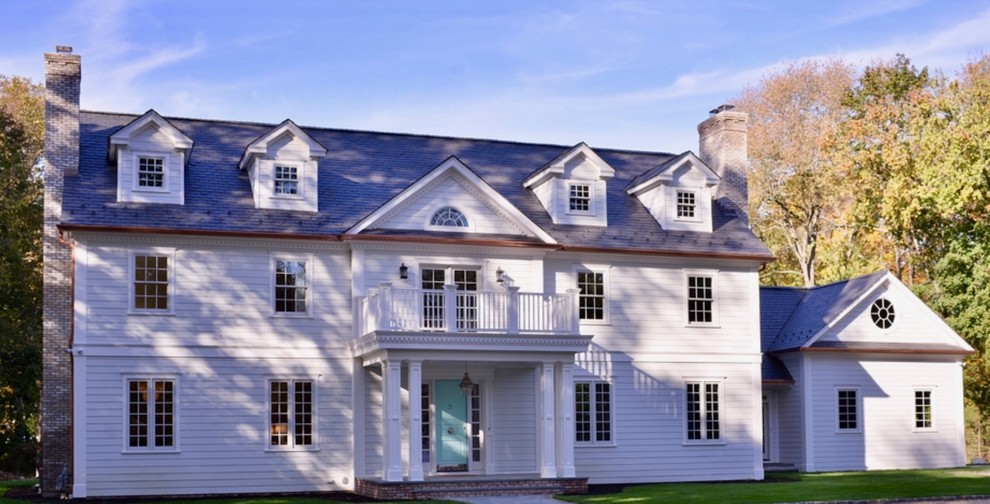 Exemple d'une très grande façade de maison blanche chic en panneau de béton fibré à un étage avec un toit à deux pans et un toit en tuile.