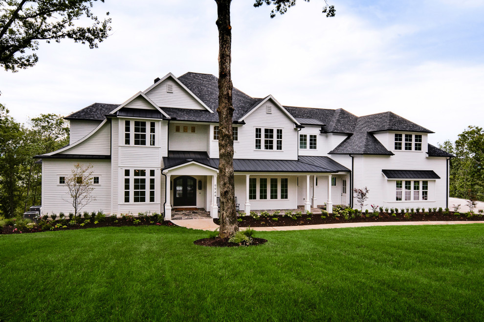 Large arts and crafts white three-story house exterior photo in Little Rock with a mixed material roof
