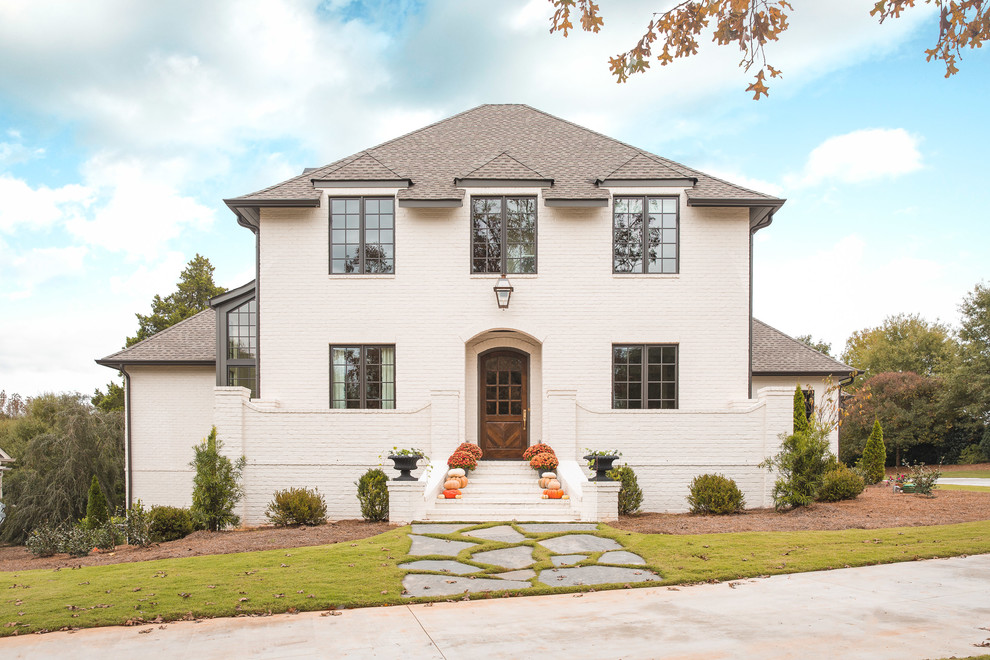 Zweistöckiges Landhausstil Einfamilienhaus mit Backsteinfassade, weißer Fassadenfarbe, Walmdach und Schindeldach in Atlanta