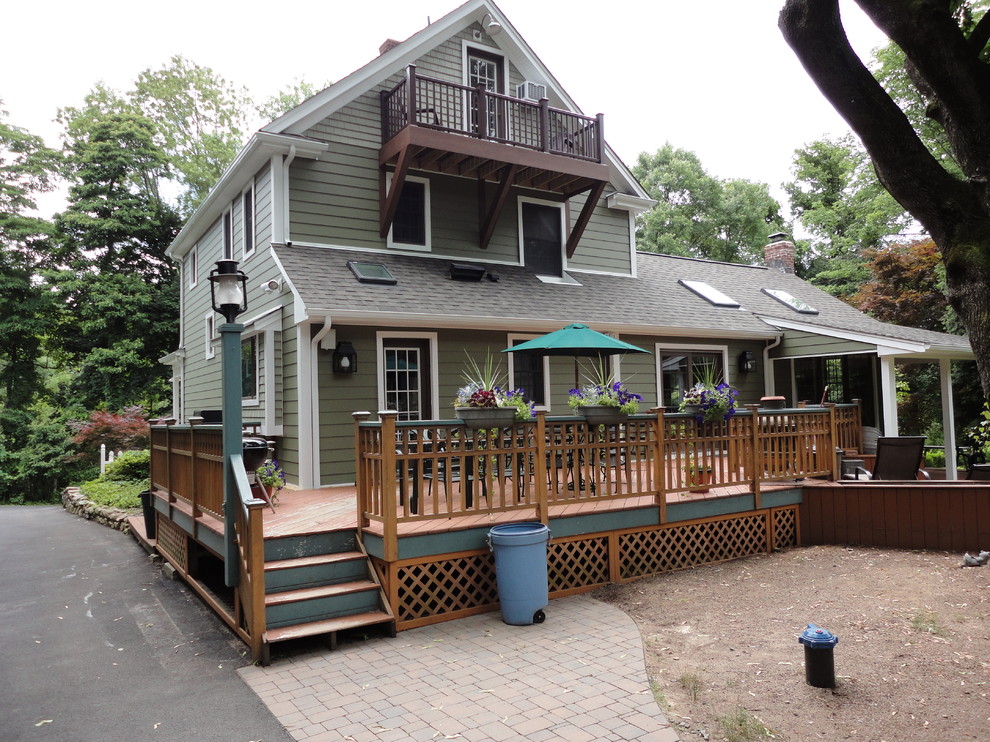 Cette image montre une grande façade de maison verte rustique avec un revêtement en vinyle et un toit à deux pans.