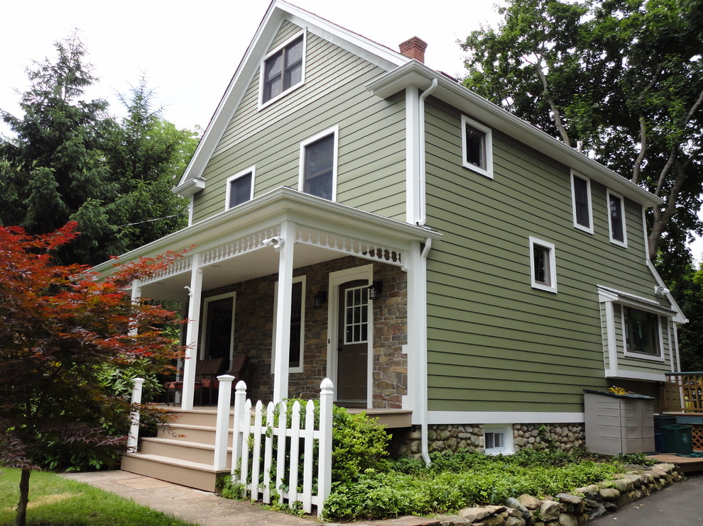This is an example of a large and green country house exterior in New York with vinyl cladding and a pitched roof.