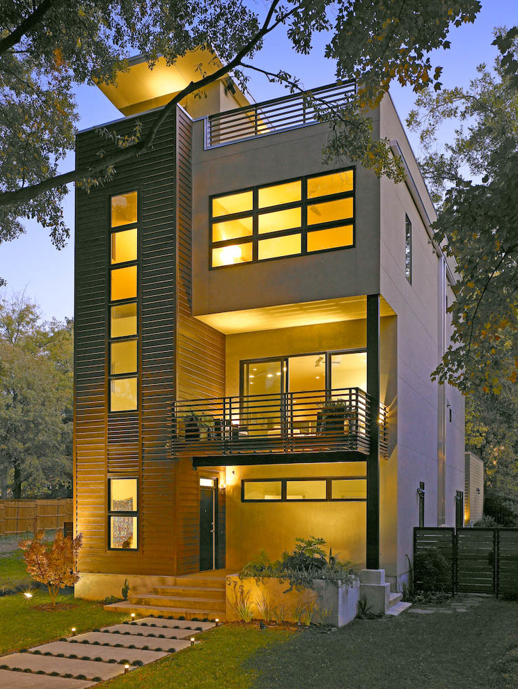 Photo of a large and brown modern detached house in Atlanta with three floors and a flat roof.