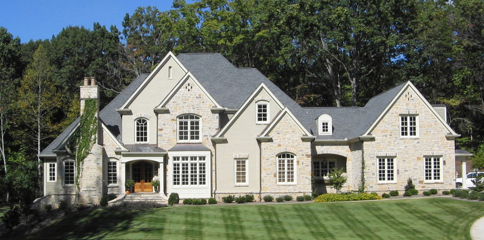 Cette image montre une façade de maison beige traditionnelle en pierre de taille moyenne et à un étage avec un toit à deux pans.
