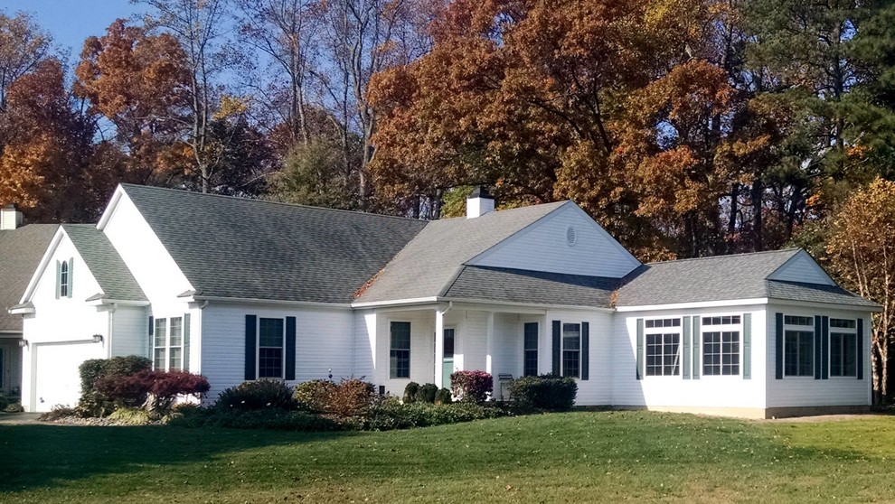 Пример оригинального дизайна: маленький, одноэтажный, белый дом в классическом стиле с облицовкой из винила и двускатной крышей для на участке и в саду