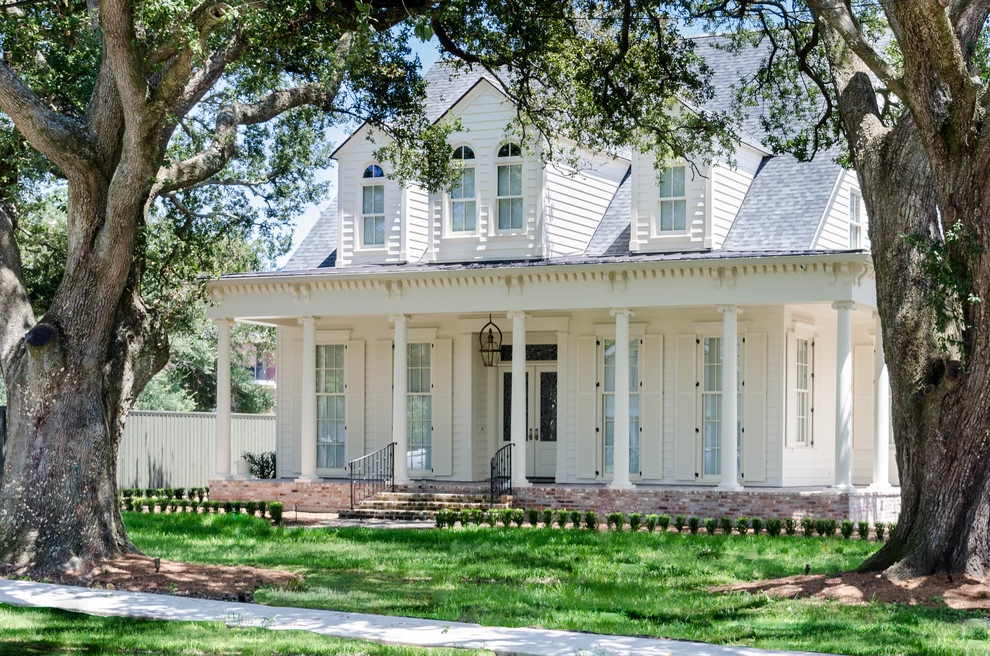 Großes, Zweistöckiges Klassisches Haus mit Faserzement-Fassade und weißer Fassadenfarbe in New Orleans