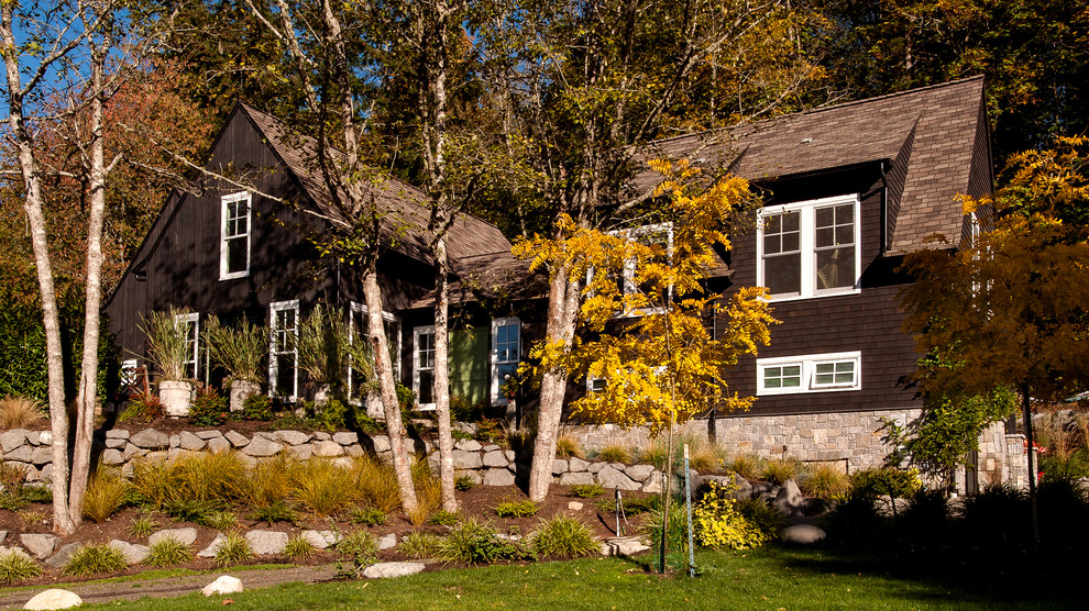 Diseño de fachada de casa marrón de estilo de casa de campo de tamaño medio de dos plantas con revestimiento de madera, tejado a dos aguas y tejado de teja de madera