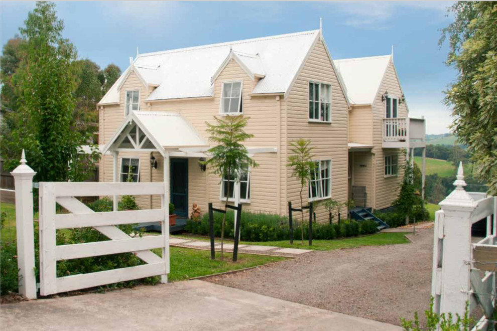 Inspiration pour une petite façade de maison beige chalet en bois à un étage avec un toit à deux pans et un toit en métal.