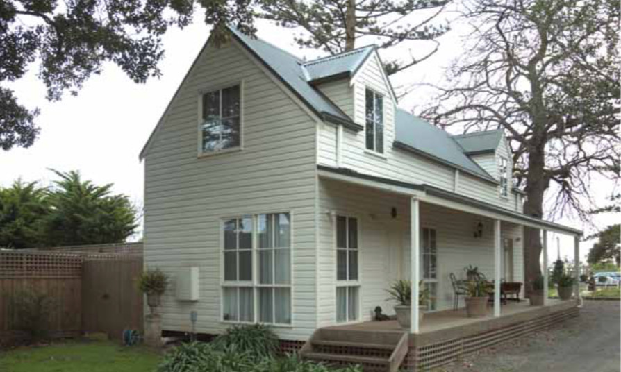 На фото: маленький, деревянный, белый частный загородный дом в стиле кантри с разными уровнями, двускатной крышей и металлической крышей для на участке и в саду