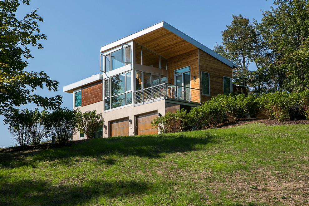 Cette image montre une grande façade de maison beige minimaliste à un étage avec un revêtement mixte et un toit plat.