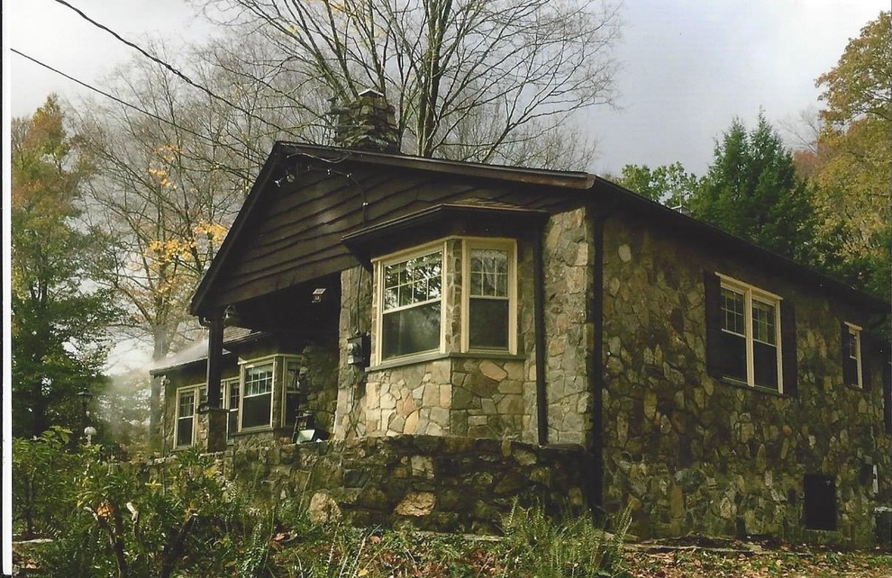 Cette image montre une grande façade de maison chalet en pierre à un étage.