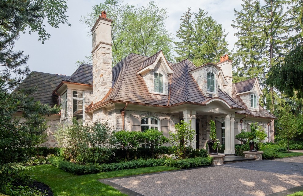 Large and beige classic two floor house exterior in Toronto with stone cladding.