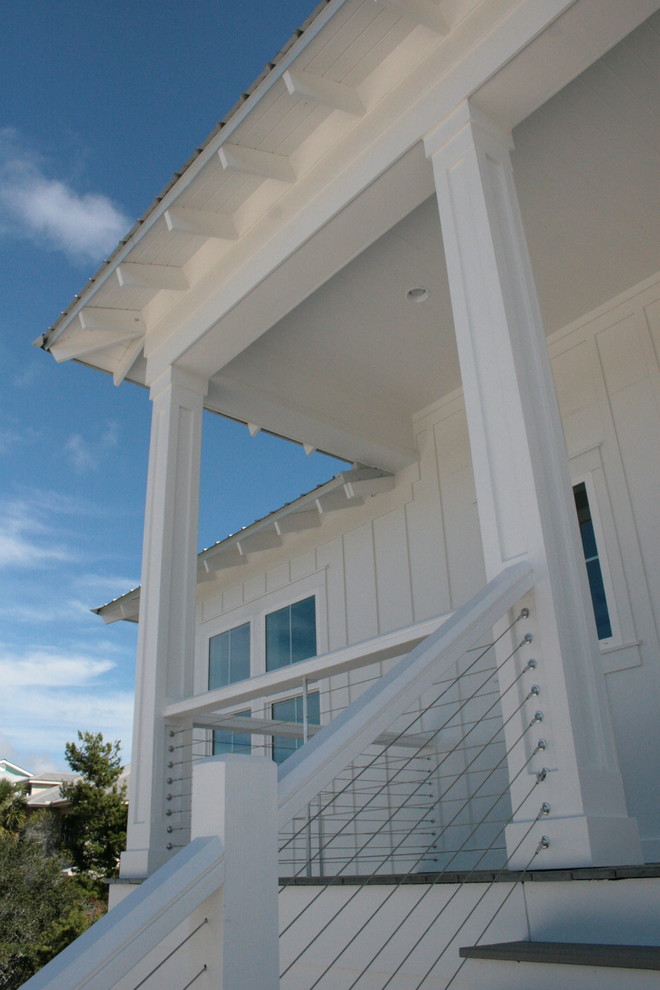 Inspiration pour une façade de maison blanche marine à un étage avec un toit à quatre pans.