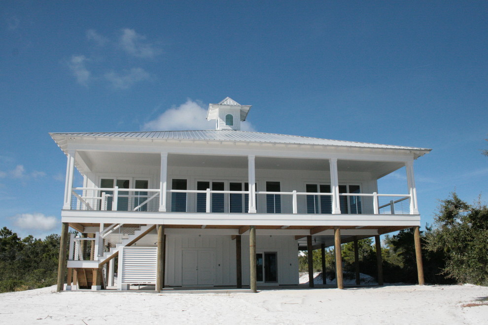 Пример оригинального дизайна: двухэтажный, белый частный загородный дом в морском стиле с вальмовой крышей и металлической крышей