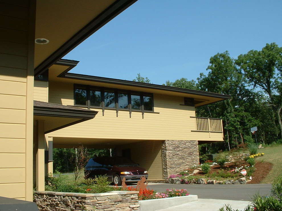Modelo de fachada beige de estilo americano grande de dos plantas con revestimiento de vinilo y tejado plano