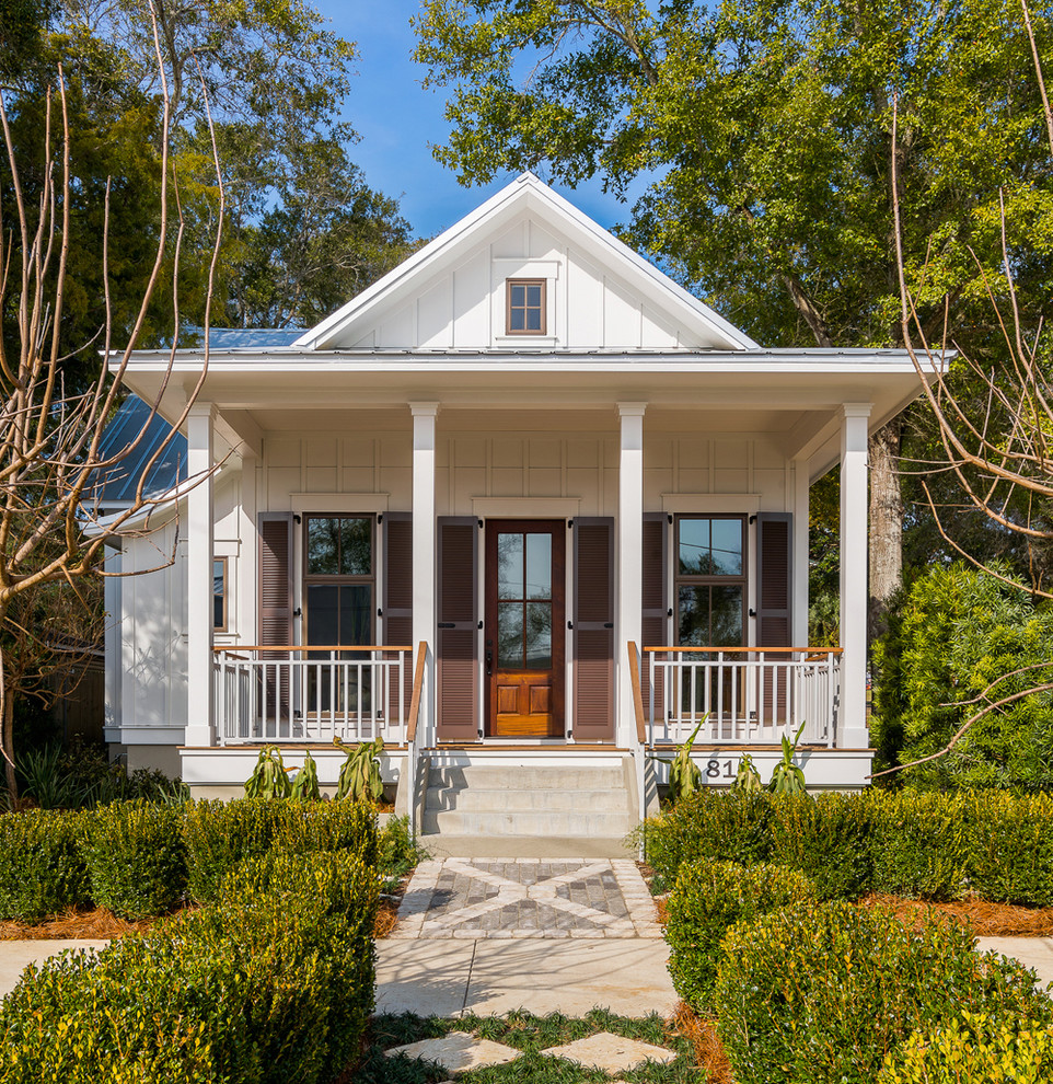 This is an example of a medium sized and white coastal bungalow house exterior in Atlanta with concrete fibreboard cladding and a pitched roof.