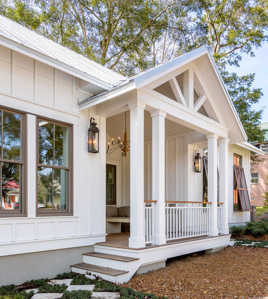 Medium sized and white beach style bungalow house exterior in Atlanta with concrete fibreboard cladding and a pitched roof.