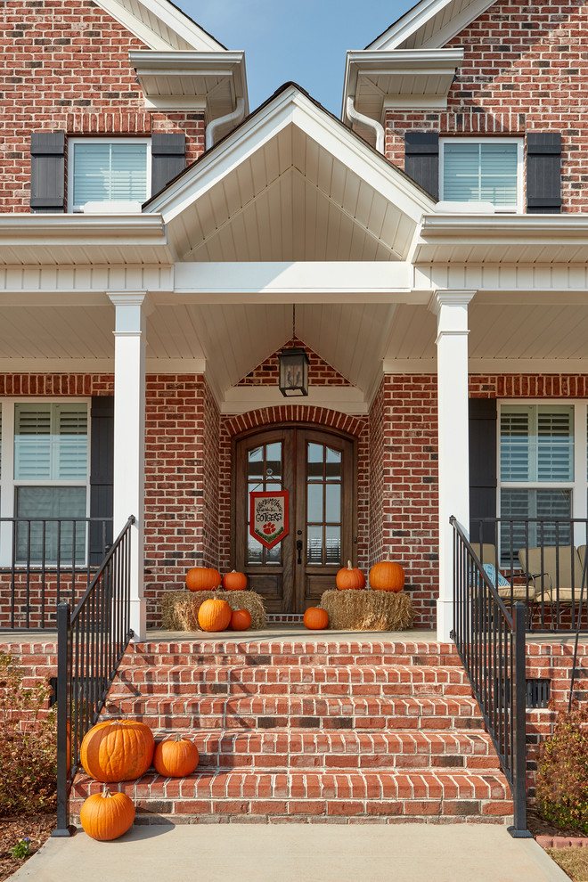 Inspiration for a mid-sized timeless red two-story brick exterior home remodel in Other with a shingle roof