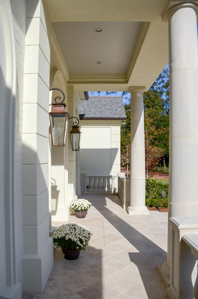 Foto della facciata di una casa grande bianca classica a un piano con rivestimento in pietra e tetto a capanna