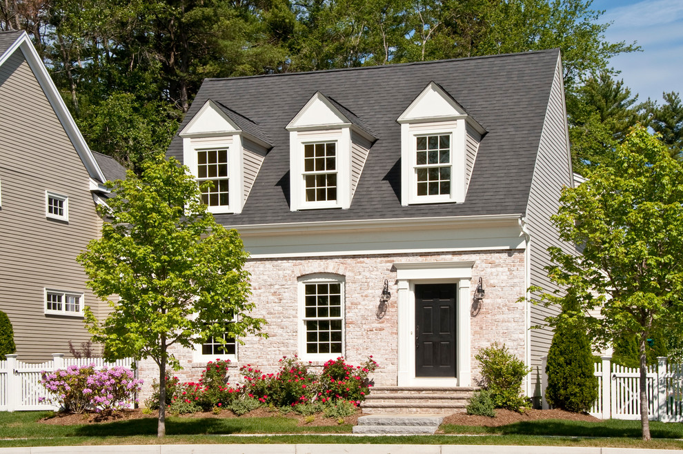 Esempio della facciata di una casa bianca classica a due piani di medie dimensioni con rivestimento in mattoni e tetto a capanna
