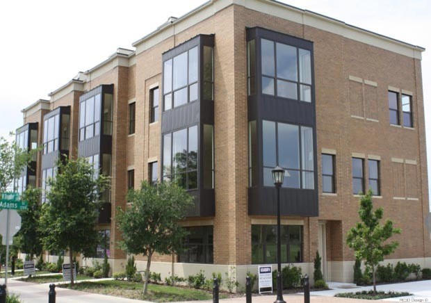 Contemporary brown three-story brick exterior home idea in Dallas