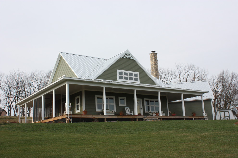 Réalisation d'une grande façade de maison verte champêtre à un étage avec un revêtement en vinyle et un toit en métal.