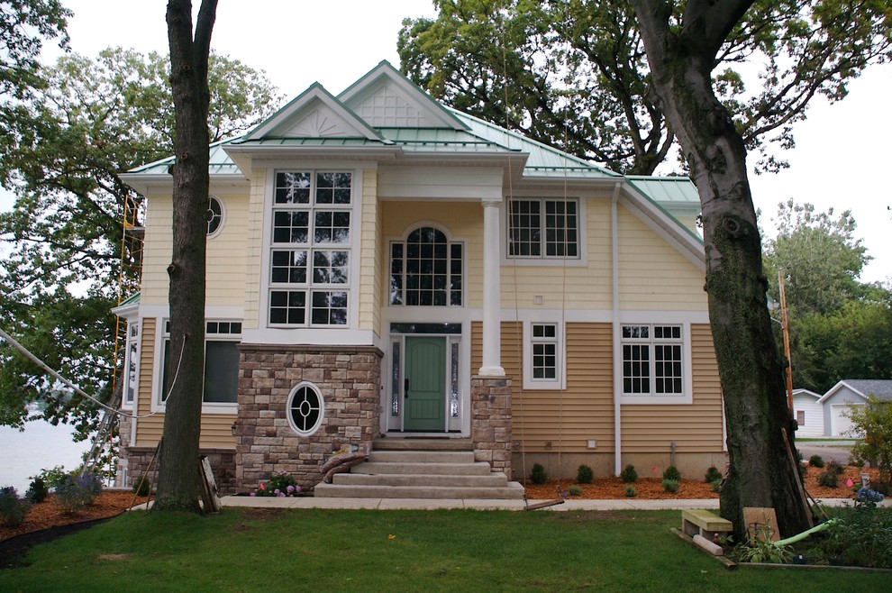 Idee per la facciata di una casa piccola gialla stile marinaro a tre piani con rivestimenti misti