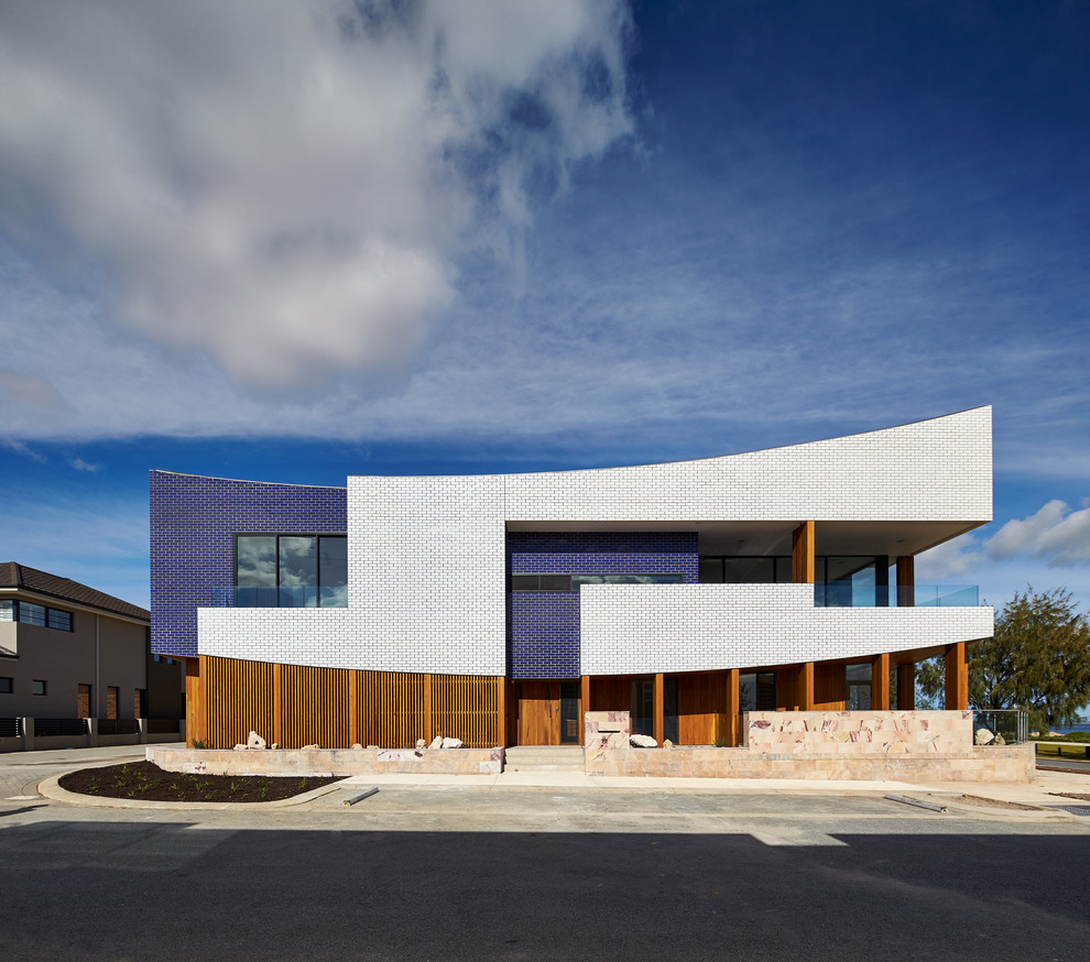 This is an example of a large contemporary two floor house exterior in Perth with wood cladding.
