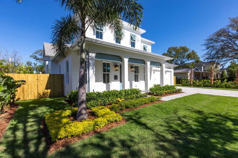 Inspiration for a mid-sized coastal white two-story vinyl exterior home remodel in Orlando with a mixed material roof