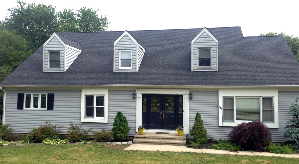 Cette photo montre une façade de maison grise moderne de taille moyenne et de plain-pied avec un revêtement en vinyle.