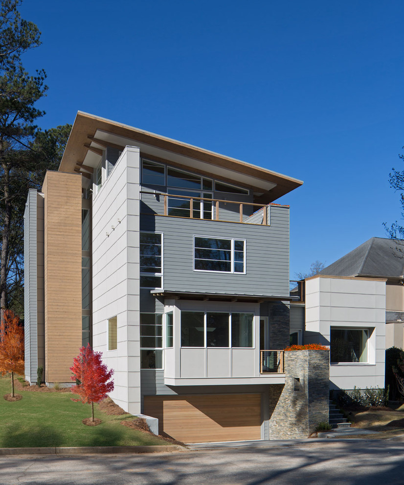 Aménagement d'une grande façade de maison grise contemporaine à deux étages et plus avec un toit en appentis et un revêtement mixte.
