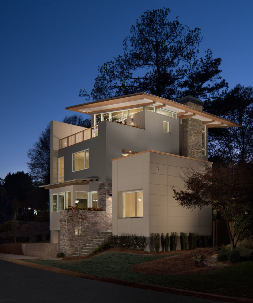 На фото: большой, трехэтажный, серый дом в современном стиле с комбинированной облицовкой и односкатной крышей с