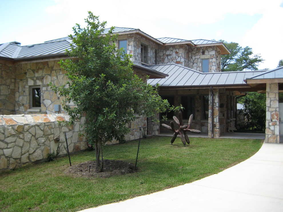Foto de fachada de casa beige actual grande de dos plantas con revestimiento de piedra