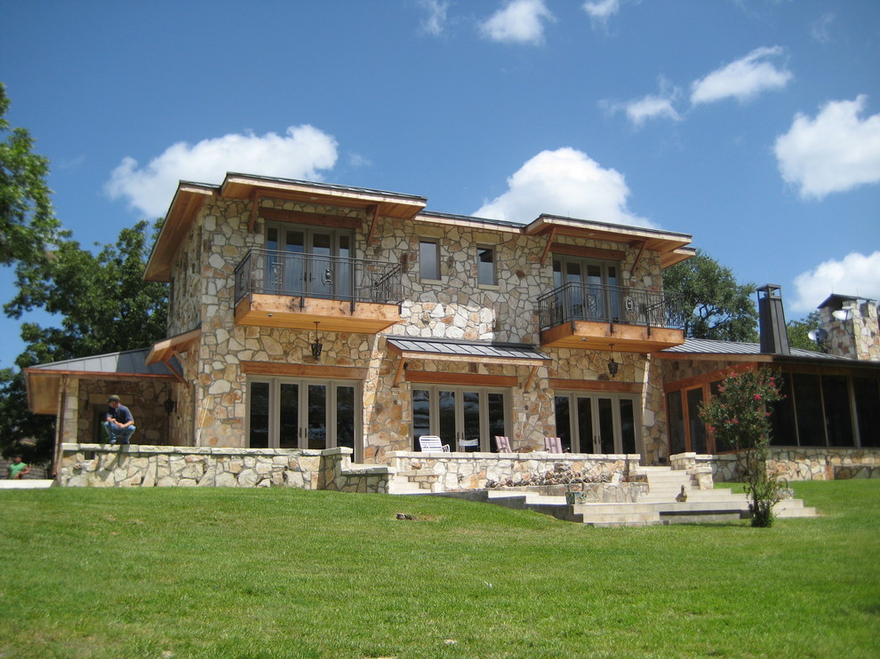 Inspiration pour une grande façade de maison beige design en pierre à un étage.