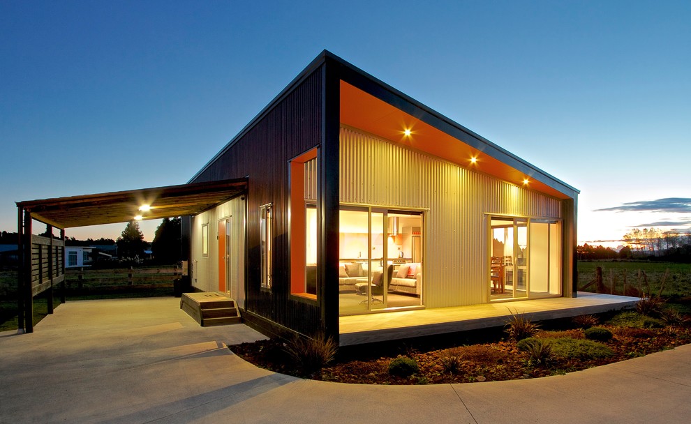 На фото: маленький, одноэтажный, разноцветный дом с облицовкой из металла и плоской крышей для на участке и в саду с