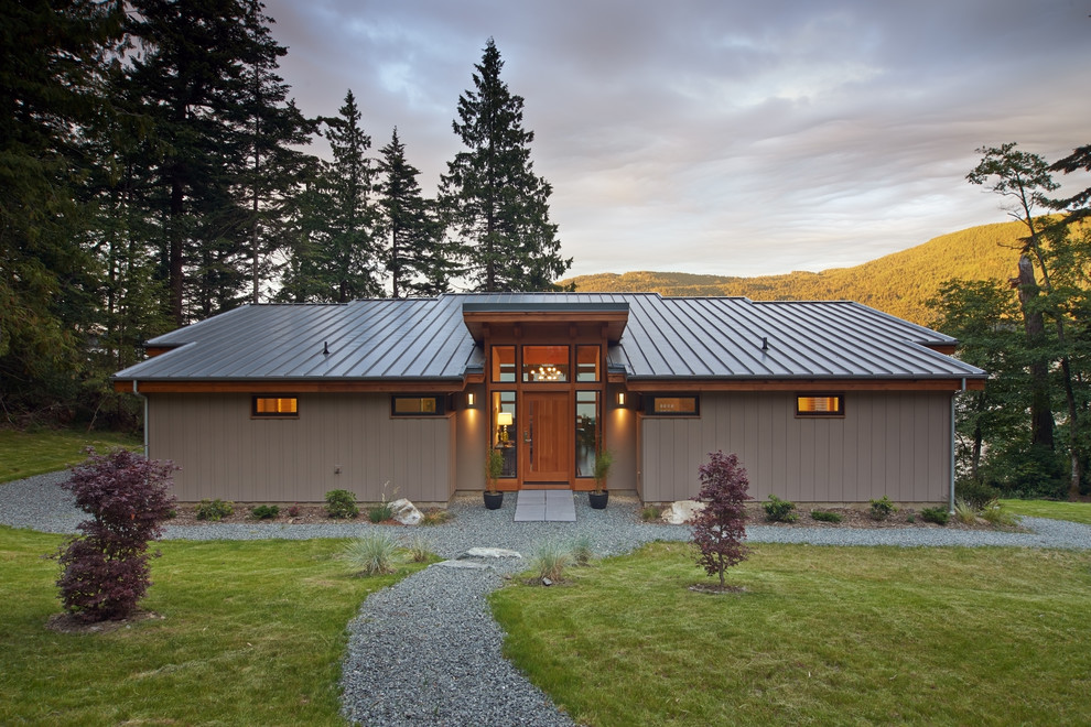 Diseño de fachada de casa gris rústica de tamaño medio de una planta con revestimiento de vinilo, tejado de un solo tendido y tejado de metal