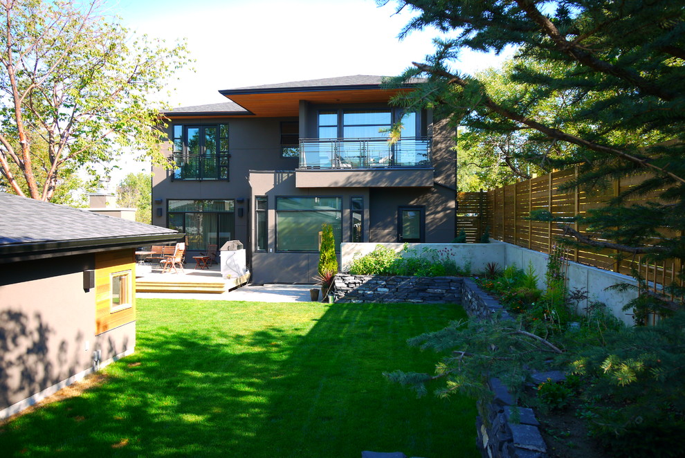 Inspiration for a large modern two floor render house exterior in Calgary.