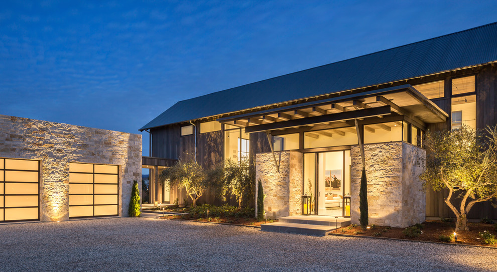 Diseño de fachada de casa gris actual grande de dos plantas con revestimiento de metal, tejado a dos aguas y tejado de metal