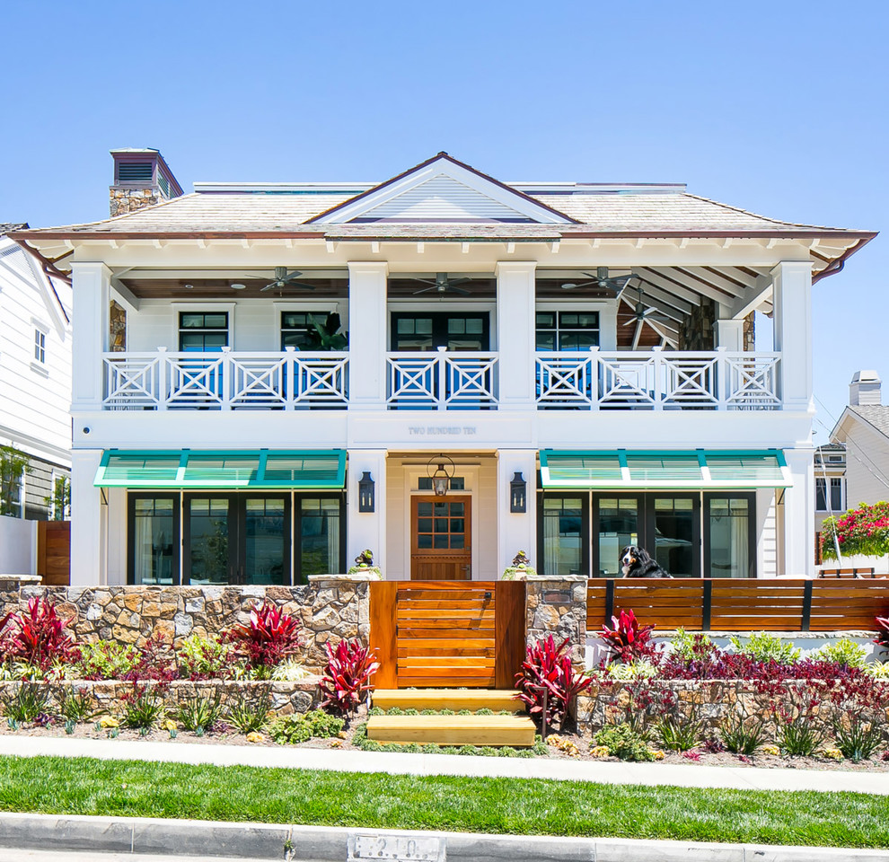 Großes, Zweistöckiges Haus mit weißer Fassadenfarbe, Walmdach und Schindeldach in Orange County