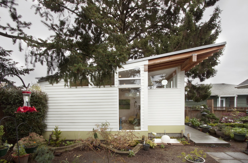 На фото: маленький, одноэтажный, деревянный, белый дом в современном стиле для на участке и в саду с