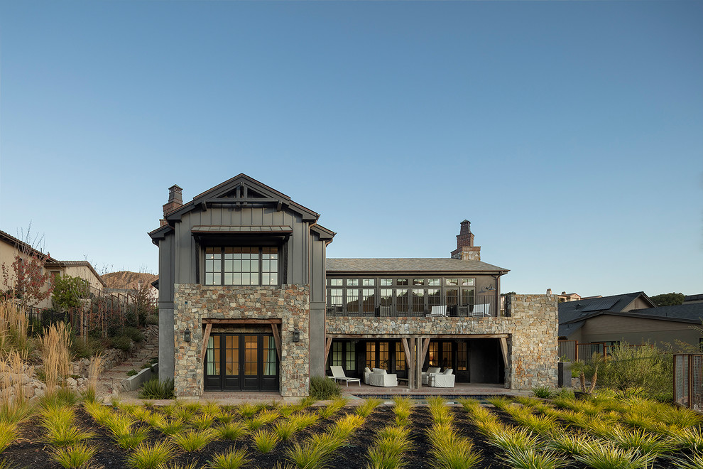 Diseño de fachada de casa gris rústica de dos plantas con revestimientos combinados, tejado a dos aguas y tejado de teja de madera