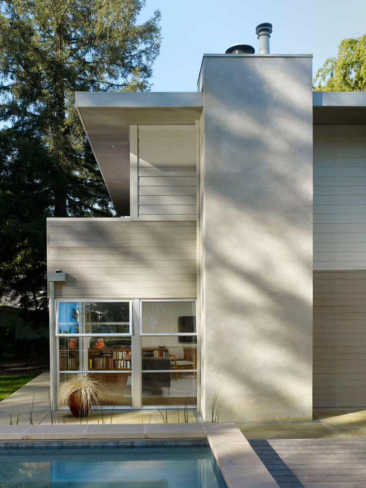Cette image montre une façade de maison minimaliste en stuc.