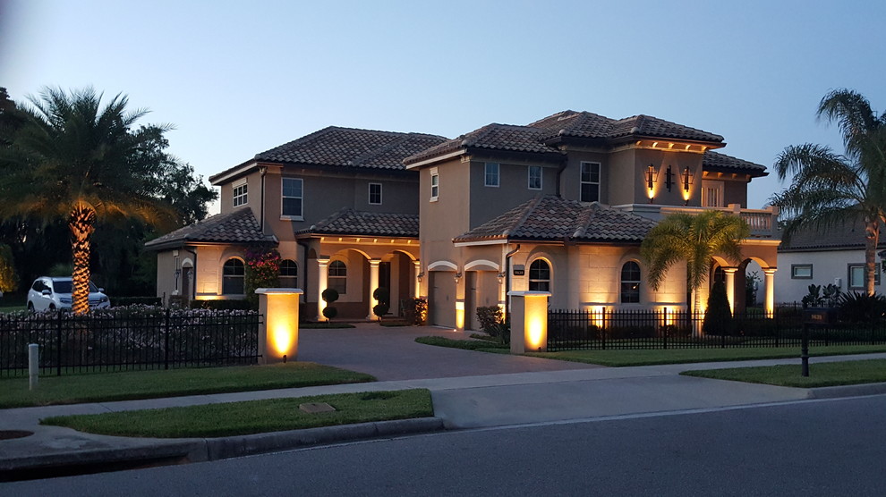 Photo of a large and beige beach style two floor house exterior in Orlando with mixed cladding and a half-hip roof.