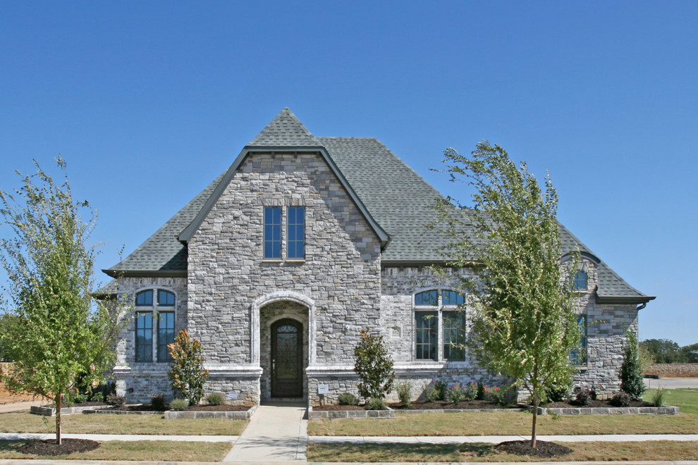 Medium sized and gey traditional bungalow house exterior in Dallas with stone cladding.