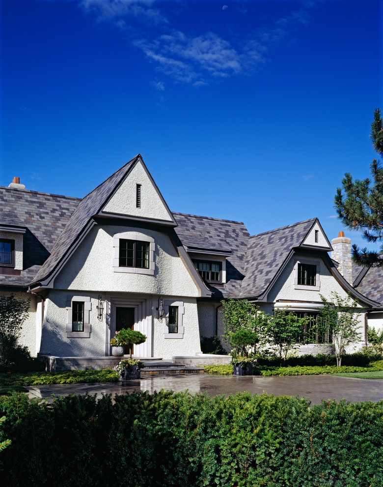 Example of a mid-sized classic white two-story stucco exterior home design in Detroit with a shingle roof